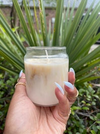 a person holding a candle in front of a palm tree